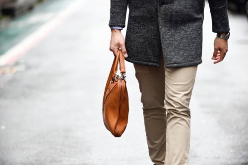 fashionable man's legs with a leather bag on the street - fashion stock pictures, royalty-free photos & images