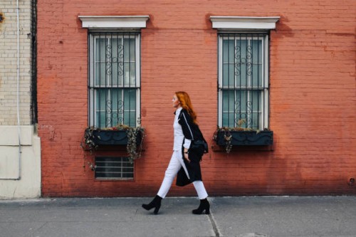 fashionable redhead woman walking by the brick wall building in west village, manhattan, ny - fashion stock pictures, royalty-free photos & images
