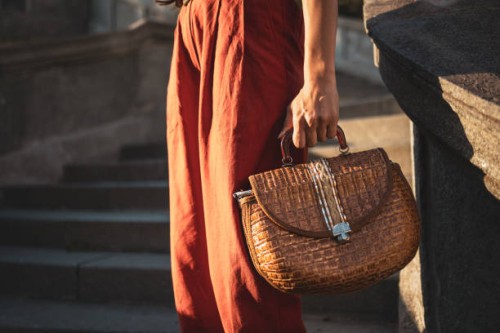 fashionable woman in red outfit holding a stylish woven handbag - fashion stock pictures, royalty-free photos & images