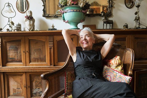 fashionable woman resting on antique chair smiling - home decoration stock pictures, royalty-free photos & images