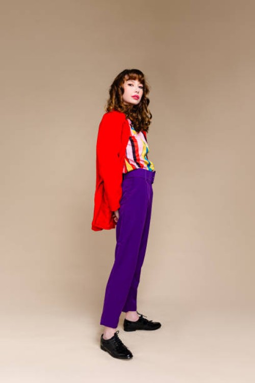 fashionable woman standing in front of plain background - fashion stock pictures, royalty-free photos & images