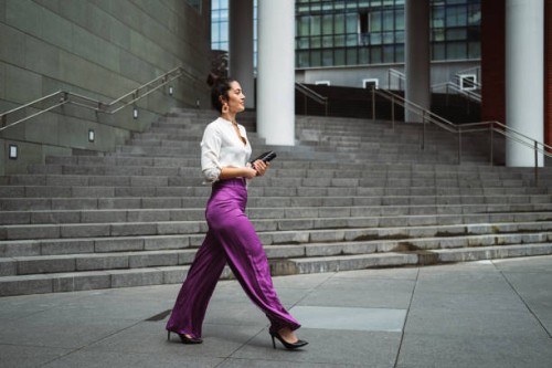 fashionable young businesswoman walking while holding diary in city - fashion stock pictures, royalty-free photos & images