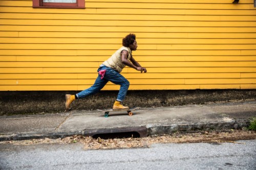fashionable young man skateboarding in front of yellow urban home - fashion stock pictures, royalty-free photos & images
