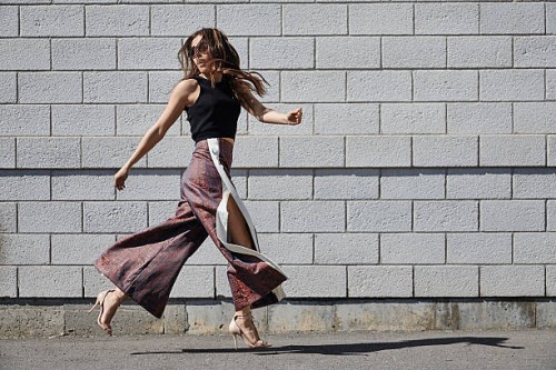 fashionable young woman passing brick wall - fashion stock pictures, royalty-free photos & images