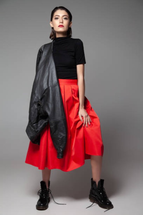 fashionable young woman standing with black jacket in studio - fashion stock pictures, royalty-free photos & images