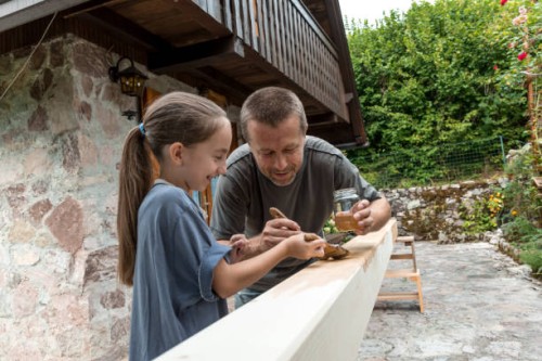 father and daughter enjoying painting roof beam together - home decoration stock pictures, royalty-free photos & images