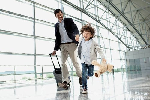 father and son (5-6) running across airport lobby - travel stock pictures, royalty-free photos & images