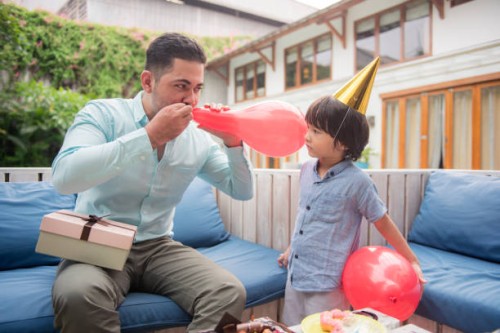 father and son blowing balloon - garden decoration stock pictures, royalty-free photos & images