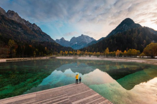 father and son enjoying the view of alpine lake - travel stock-fotos und bilder