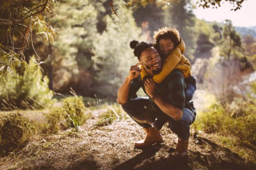 father and son having fun with piggyback ride in forest - travel stock pictures, royalty-free photos & images
