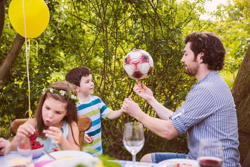 father and son playing with soccer ball on a garden party - garden decoration stock pictures, royalty-free photos & images