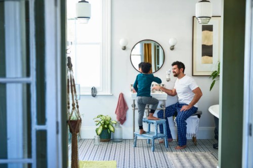 father helping son brushing teeth in bathroom - home decoration stock pictures, royalty-free photos & images