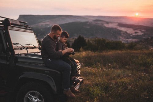 father teaching son to photograph on old film photo camera outdoors at sunset - travel stock pictures, royalty-free photos & images