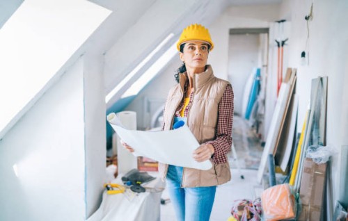 female architect looking at blueprints on construction site - home decoration stock pictures, royalty-free photos & images
