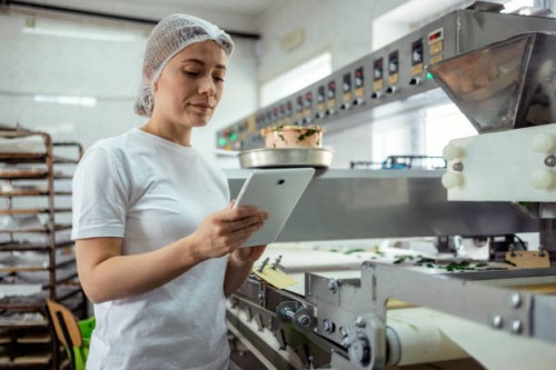 female baker with digital tablet in the bakery - food stockfoto's en -beelden
