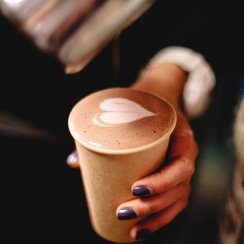 female barista holding disposable cup of coffee with heart shape - nails art stock pictures, royalty-free photos & images
