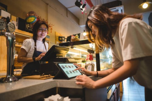 female customer buying food on digital tablet at cashier counter - food stock pictures, royalty-free photos & images