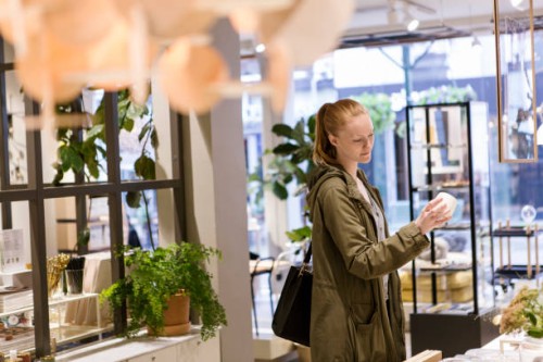 female customer looking at object while standing in store - home decoration stock pictures, royalty-free photos & images