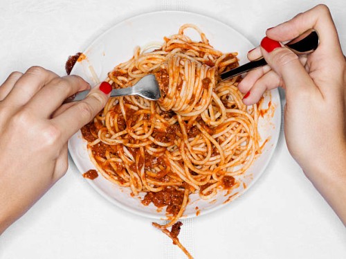 female eating spaghetti, overhead view - junk food stock pictures, royalty-free photos & images