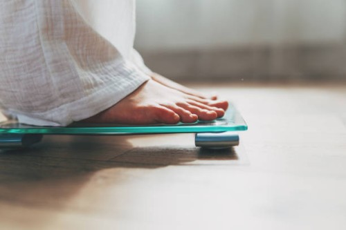 female feet standing on electronic scales for weight control on wooden background. the concept of slimming and weight loss - fashion stock pictures, royalty-free photos & images