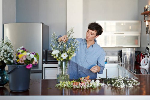 female florist organising flowers for customer from home - home decoration stock pictures, royalty-free photos & images