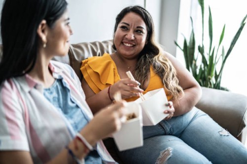female friends eating yakisoba in the living room at home - junk food stock pictures, royalty-free photos & images