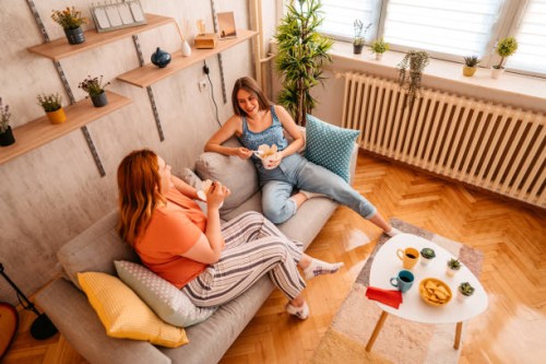 female friends enjoying takeaway meal at home - junk food stock pictures, royalty-free photos & images