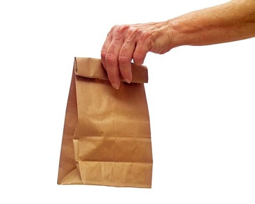 female hand holding out a lunch bag - junk food stock pictures, royalty-free photos & images