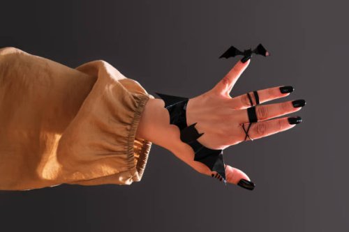 female hand with black manicure and decor in the shape of a bat. halloween theme. - nails art photos et images de collection