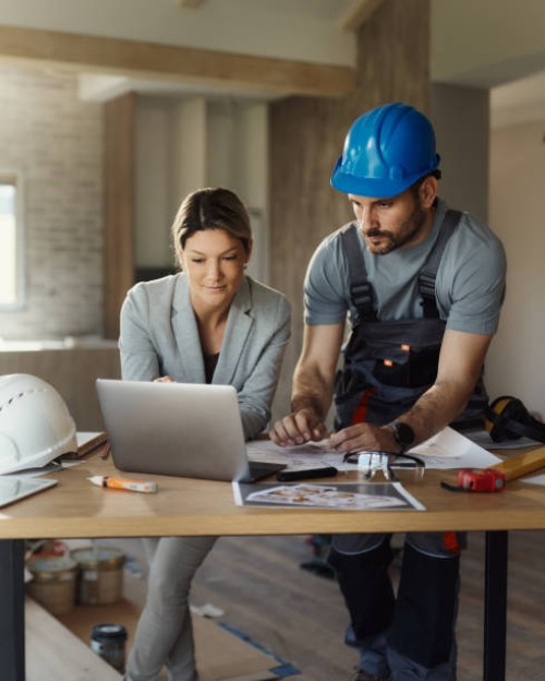 female inspector and manual worker using laptop at renovating house. - home decoration stock pictures, royalty-free photos & images