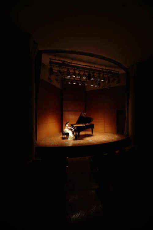 female pianist playing grand piano at concert hall - concert stock pictures, royalty-free photos & images