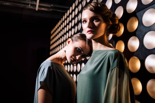 female portrait of two fashion woman at the backstage of fashion week show. lifestyle photography, behind the scenes of new clothing collection. girls wear by fashion designer. wall with lights - fashion stock pictures, royal