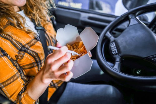 female truck driver eating on lunch break in truck's cabins - junk food stock pictures, royalty-free photos & images