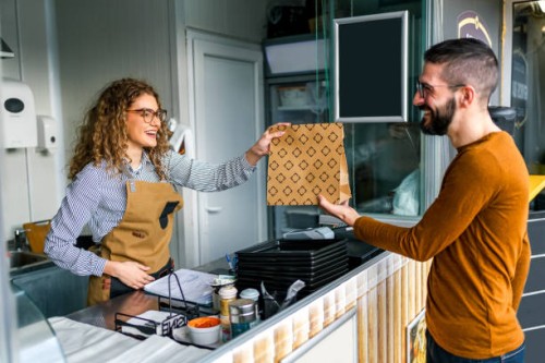 female worker giving order to customer in a fast food restaurant - junk food stock pictures, royalty-free photos & images