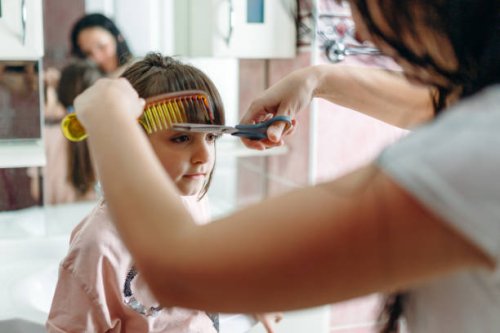 femme essayant de couper les cheveux de sa fille à la maison - hairstyle photos et images de collection