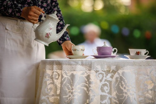 femme ramassant la tasse de thé pour servir à son mari pour le thé de l’après-midi - garden decoration photos et images de collection