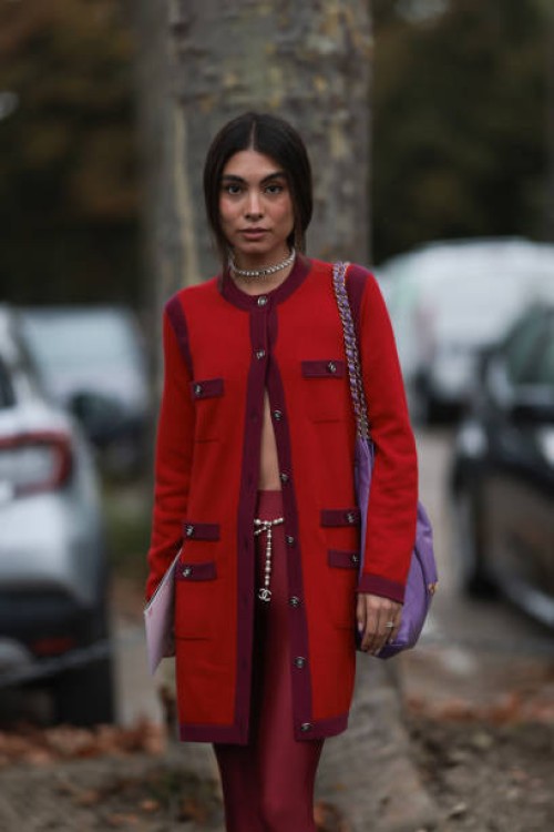 Fer Millán Delaroière is seen outside Chanel show wearing Chanel pearl necklace, red and lilac Chanel cardigan, lilac Chanel 22 tote bag, red high...