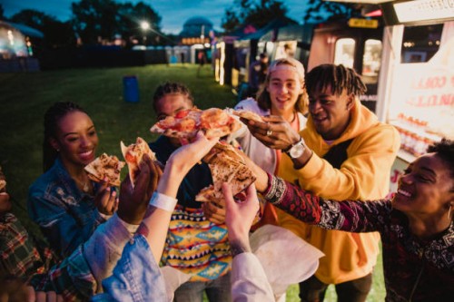 festival goers sharing pizza - food stock pictures, royalty-free photos & images
