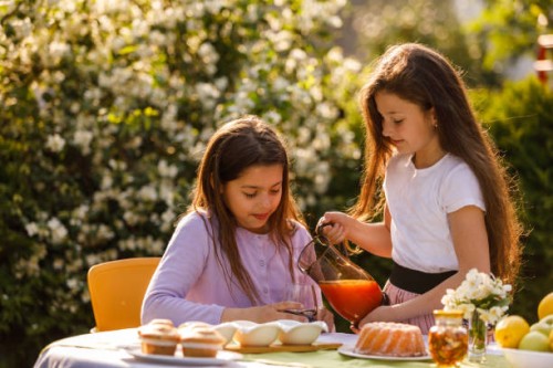 filles servant des boissons et des collations tout en profitant du soleil dans le jardin - garden decoration photos et images de collection
