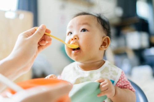 first meal dirty and messy asian mother try to feeding first meal for her daughter (2-6 month) at home - food stock pictures, royalty-free photos & images