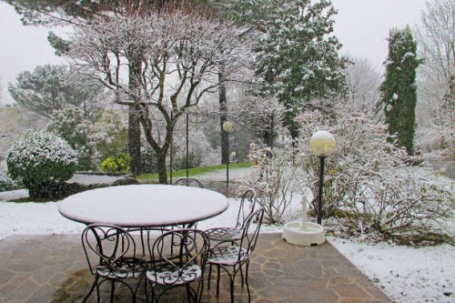 first snow, patio with table and chairs, meadow and trees - garden decoration photos et images de collection