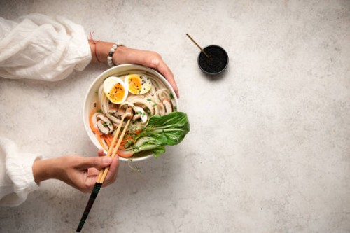 flat lay of noodle bowls with hands - food stock pictures, royalty-free photos & images
