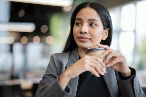 flexible working anywhere for young business entrepreneur. portrait of confident young businesswomen holding a coffee cup while working in a lobby hotel during business trip. - junk food stock pictures, royalty-free photos & 