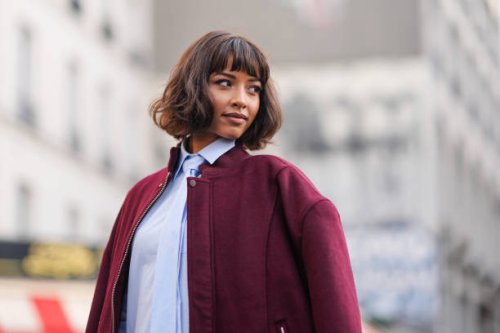 Flora Coquerel wears a burgundy oversized bomber jacket , a pastel pale blue long shirt / midi dress with a tie, outside Casablanca, during the...