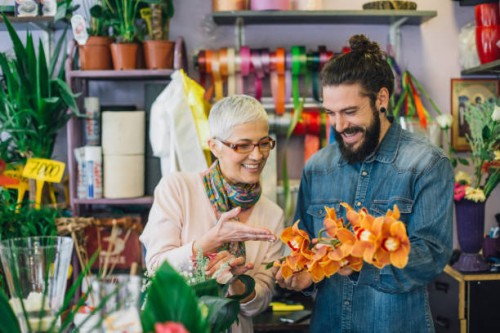 florist and a young man making a flower arrangement - garden decoration stock pictures, royalty-free photos & images