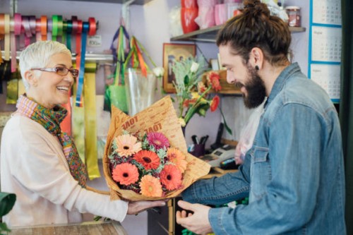 florist is giving a flower arrangement to a man - garden decoration stock pictures, royalty-free photos & images