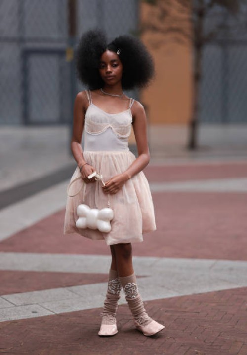 Flowerovlove is seen wearing a complete Simone Rocha look, consisting of silver rhinestones necklace; a knee-length, rose mesh dress with spaghetti...
