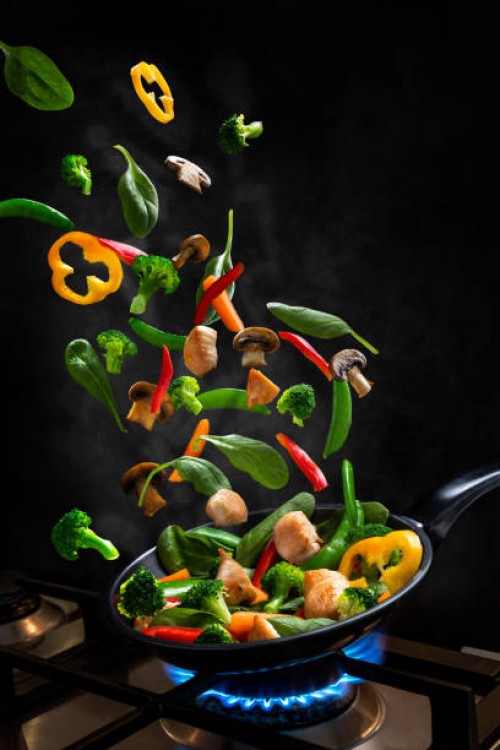 flying chicken and vegetable stir fry, into a frying pan - food stock pictures, royalty-free photos & images