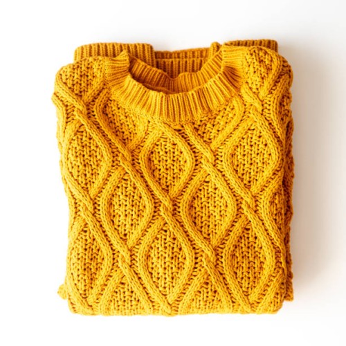 folded yellow sweater on a table, top view - fashion stock pictures, royalty-free photos & images
