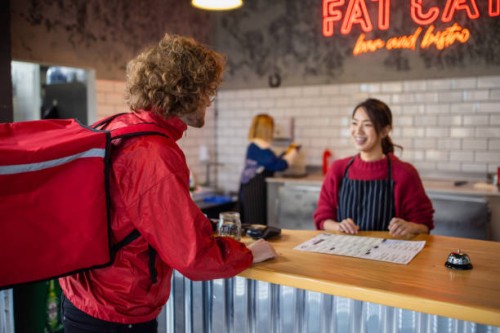 food delivery person at the fast food restaurant waiting to pick up the order - junk food stock pictures, royalty-free photos & images
